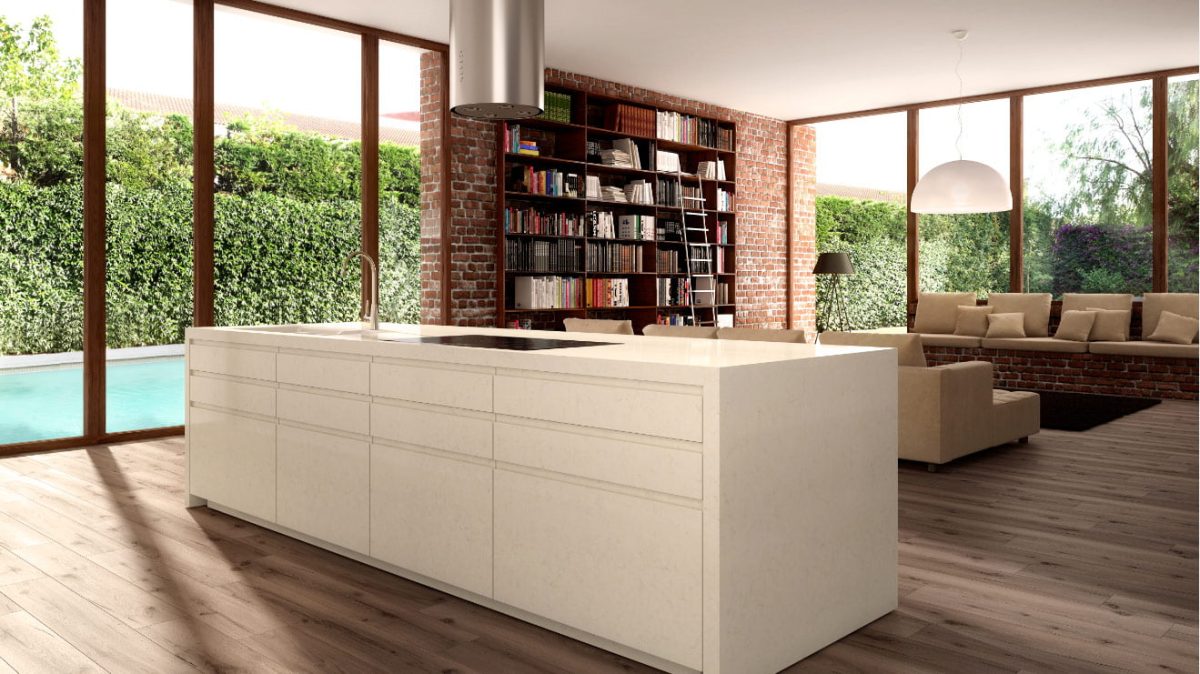 A kitchen with a cream quartz worktop, wooden floor boards and brick book shelf.