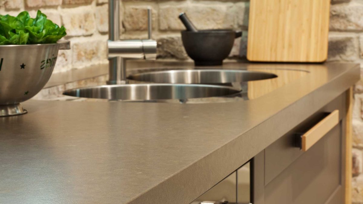 Close up of brown quartz worktops with double sinks.