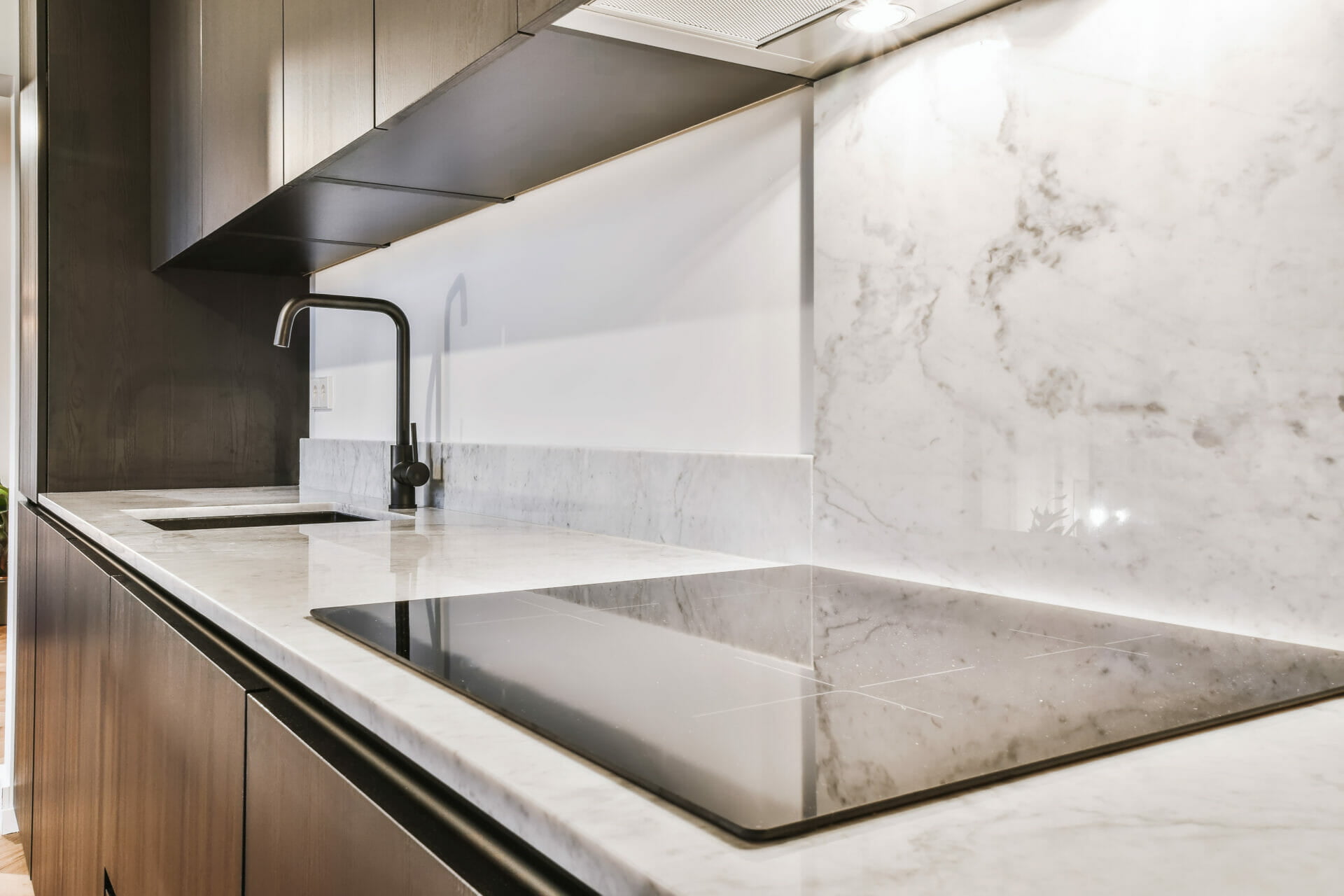 Close up of granite splashbacks and worktops, stove top and faucets